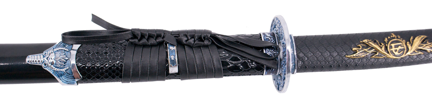 Katana S2023 de 101,5 cm hoja de acero, vaina de madera negra lacada con detalles metálicos e imitación de piel de serpiente, mango con imitación de piel de sepriente negra de polipiel. Con soporte. Ref. S2023